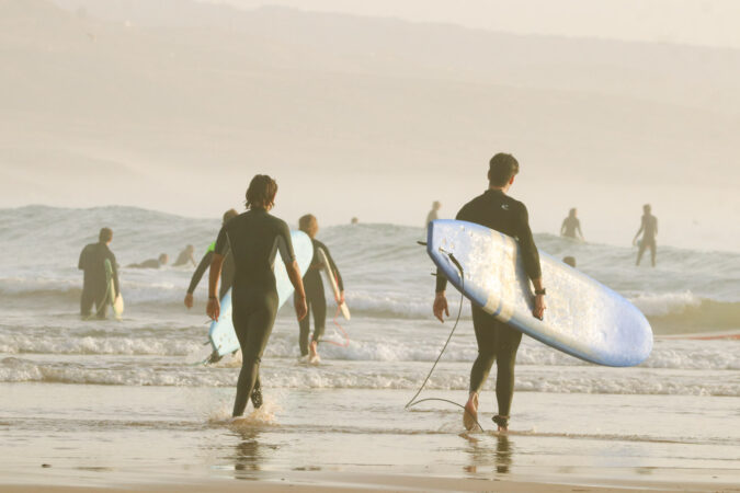 Two people walking into the water at The Bay